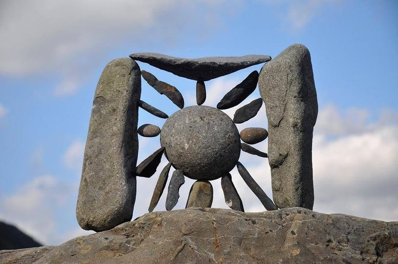 a photo of a stone gate with a large round stone in the middle